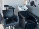 une chaise noire et un lavabo blanc dans une pièce