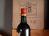 a bottle of wine sitting on a table next to a box of wine