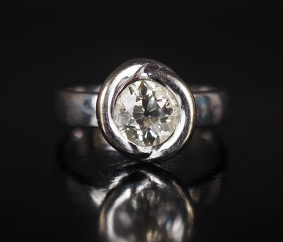 un gros plan d'une bague en diamant blanc posée sur une surface noire