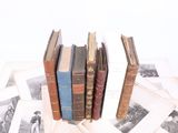 several old books are stacked on top of each other on a table