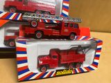 deux camions de pompiers rouges dans une boîte posée sur une table