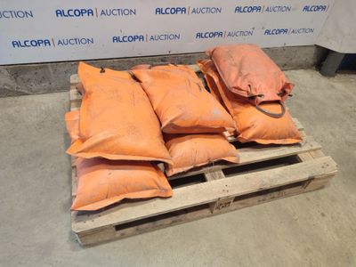 several bags of sand sitting on top of a pallet in front of a wall