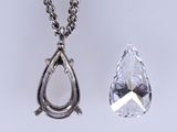 two pieces of jewelry are displayed on a white surface