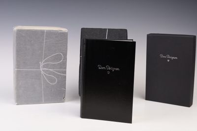 trois livres en noir et blanc sont alignés sur une surface blanche