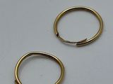 two small gold rings on a white surface