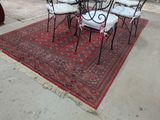 quatre chaises et une table posées sur un tapis rouge