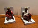 deux figurines d'un homme et d'une femme assis sur un banc