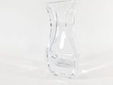 a clear glass vase with a curved base on a white surface