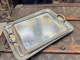 un plateau en argent posé sur une vieille valise