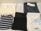 several pairs of pants and shirts are laid out on a table