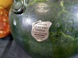 a watermelon with a sticker on it sitting next to a bunch of bananas