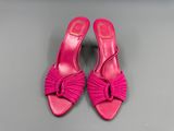des chaussures roses ornées d'un nœud sur le côté, posées sur un fond gris