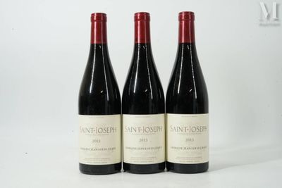 trois bouteilles de vin sont alignées sur une surface blanche