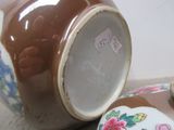 un vase marron et blanc posé à côté d'un récipient marron et blanc