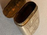 a small silver box with a lid on a table