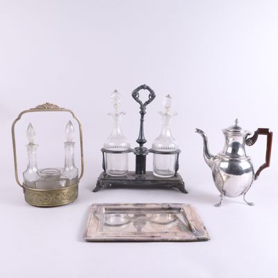 Plusieurs objets en argent et en verre sont exposés sur une surface blanche
