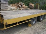 un camion à plateau jaune garé à côté d'un tas de pierres