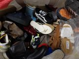 many pairs of shoes in a plastic bag on the floor