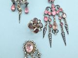 deux paires de boucles d'oreilles et une broche posées sur un fond bleu