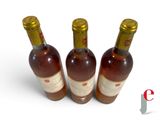 three bottles of wine sitting next to each other on a white surface