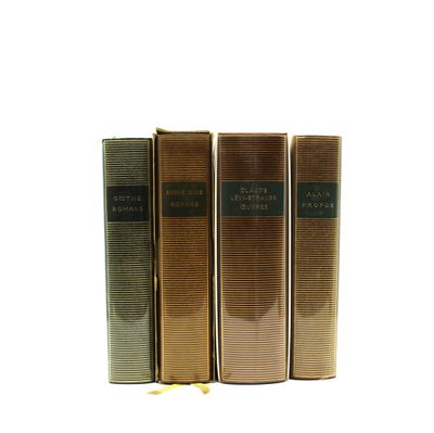 trois livres superposés sur une surface blanche