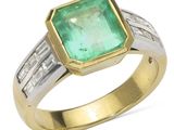 un gros plan d'une bague sertie d'une émeraude et de diamants