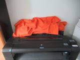 une imprimante noire surmontée d'un tapis orange