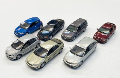 plusieurs petites voitures sont alignées sur une surface blanche
