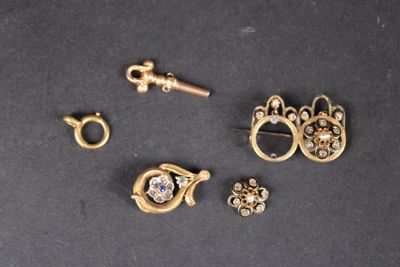 three pairs of earrings and a key on a black surface