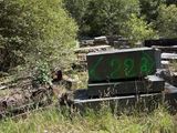 a pile of rocks with graffiti on them in the woods