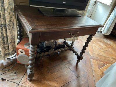 une petite table en bois sur laquelle est posé un ordinateur portable