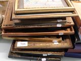 a pile of framed pictures on a table in a room