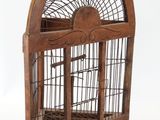 une cage à oiseaux en bois avec un oiseau à l'intérieur