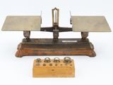 a small scale with a wooden base and a wooden stand