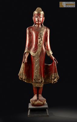 une statue rouge et dorée représentant une personne debout sur un socle