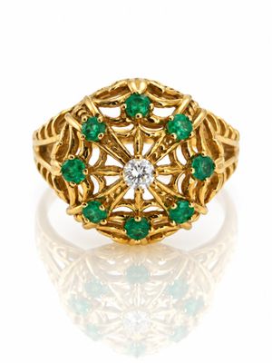 Gros plan sur une bague en or ornée d'émeraudes et de diamants