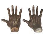 pair of bronze hand sculptures on a white background