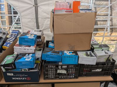 de nombreuses boîtes contenant du matériel électronique posées sur une table dans une tente