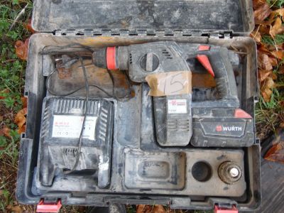 une mallette à outils contenant des outils, posée par terre