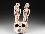 un gros plan d'une sculpture représentant deux personnes sur un crâne