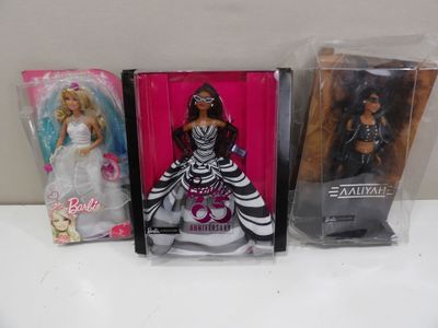 Trois poupées Barbie sont alignées dans des sacs en plastique sur une table