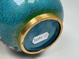 a blue vase with a gold rim sitting on a table