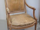 a wooden chair with a tan upholstered upholstered seat