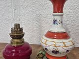 pair of antique lamps on a wooden table with a white wall in the background