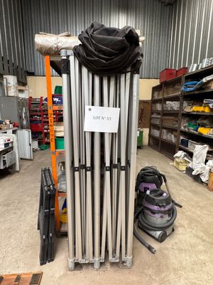 a stack of metal pipes in a warehouse with a sign on it