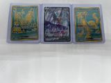 trois cartes à collectionner Pokémon différentes, dans des pochettes en plastique, posées sur une surface blanche