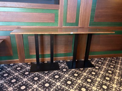 une table en bois avec deux pieds noirs et un piètement noir
