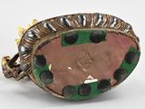 a picture of a ring with a pink and green stone