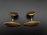 une paire de boutons de manchette en or sur fond noir
