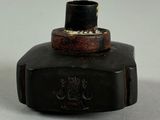 a small black bottle with a black top on a table